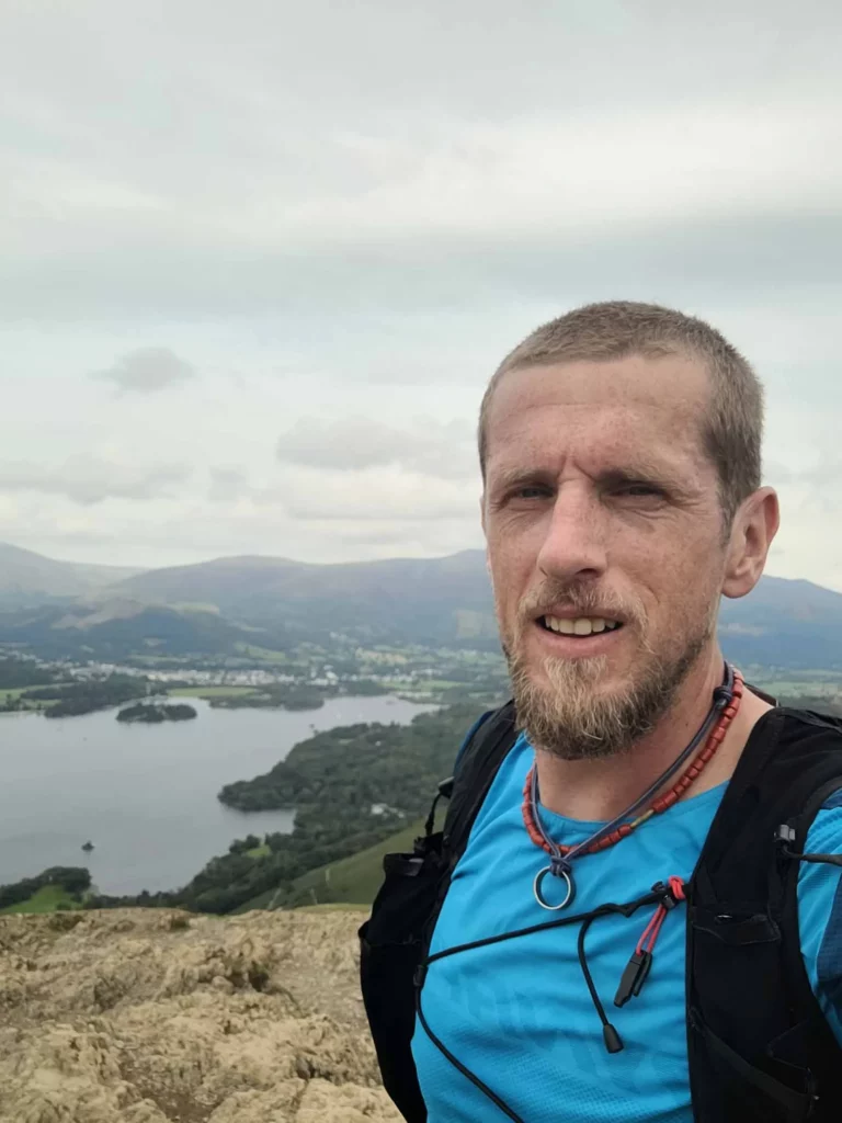 ultra runner Ross Jenkin profile shot, him stood on a rocky section in the high hills