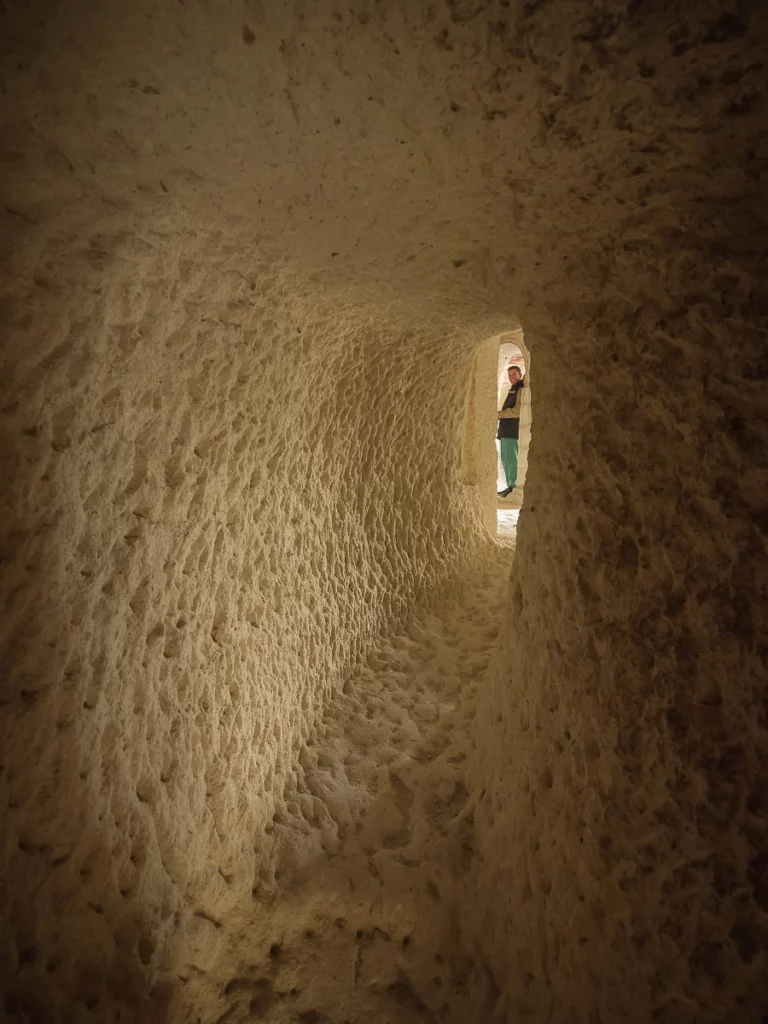 a long stone tunnel, a man just visible at the end