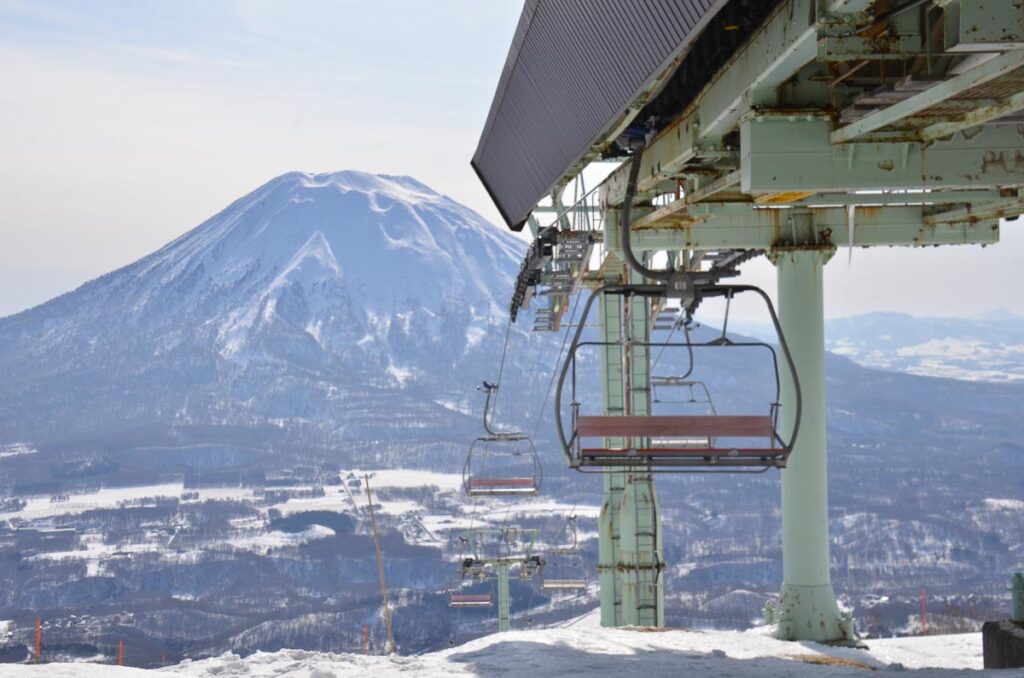 the old Hirafu Center Four lift, shot from the top station, a volcanic soft-topped mountain behind it across the valley