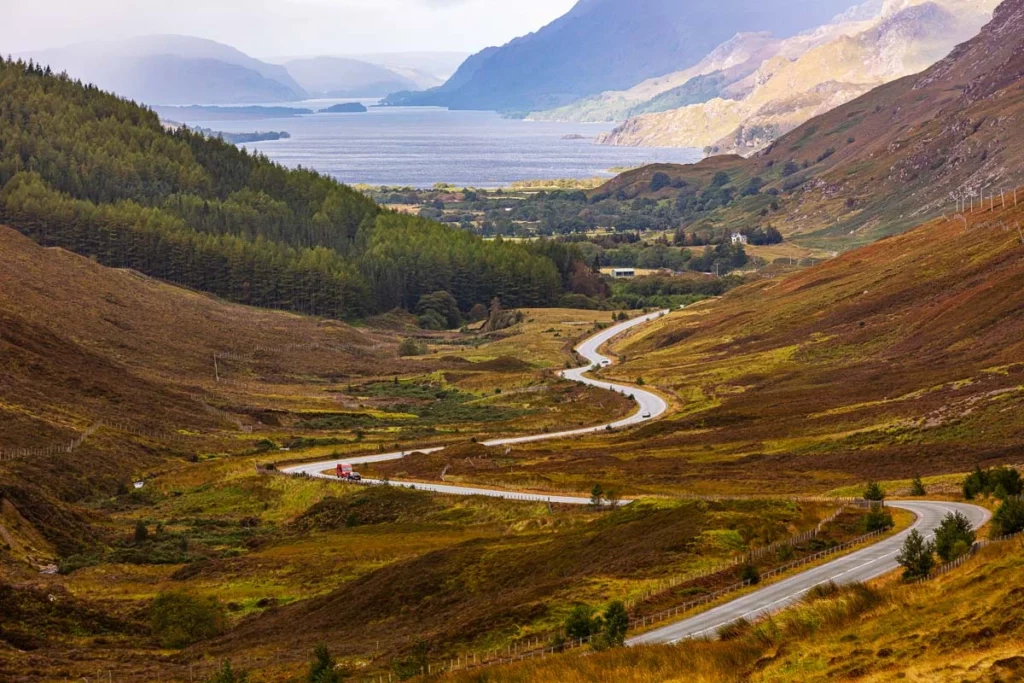 aerial shot of stunning Scottish scenery - a winding road through a golden valley