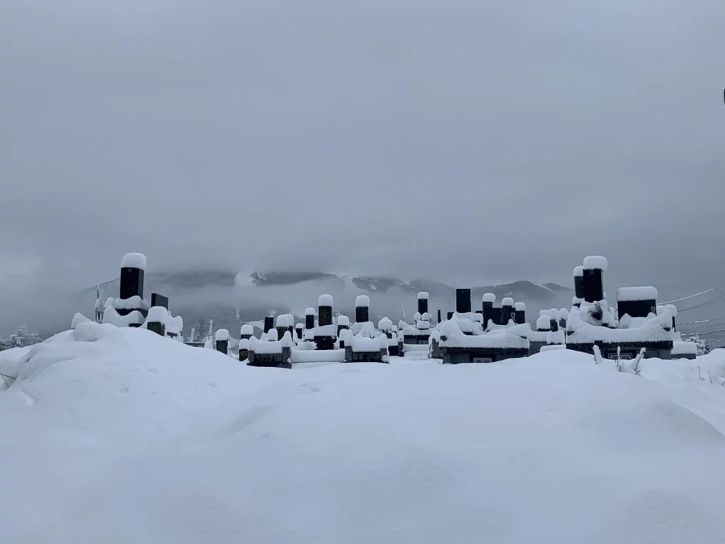 a small Japanese graveyard covered in snow