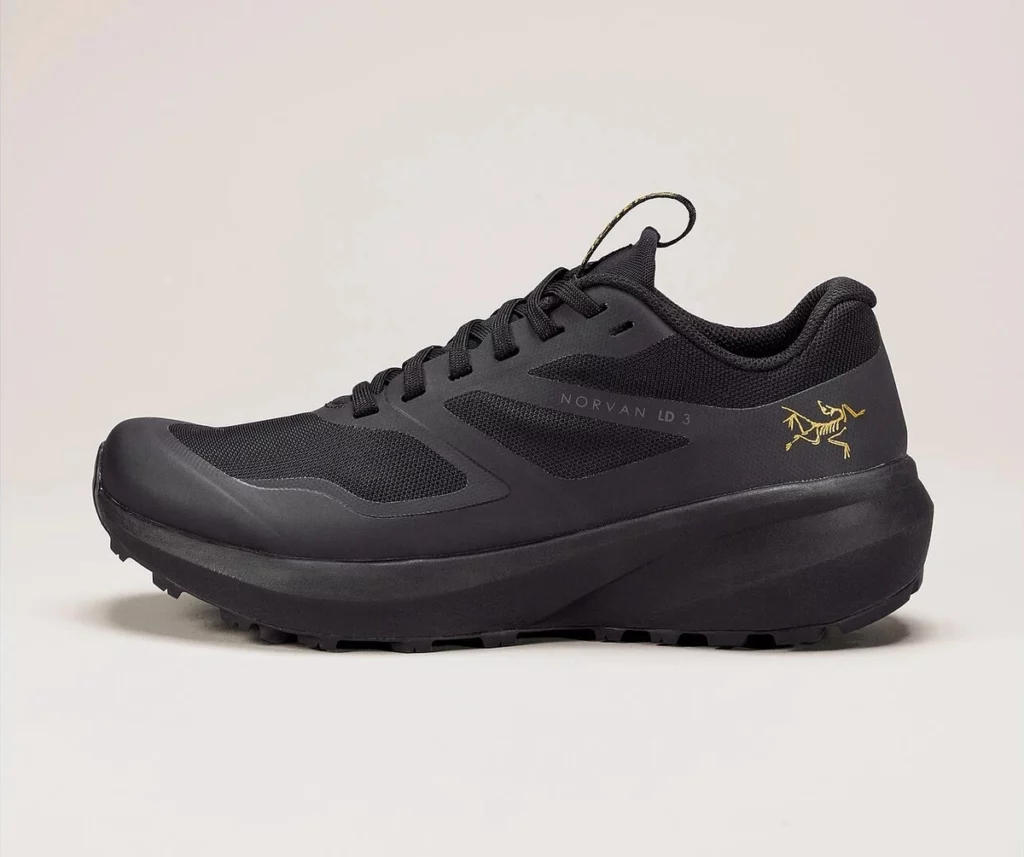 black trail running shoe by Arc'teryx on a pinkish background