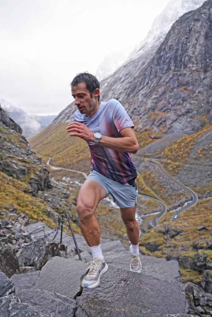 Ultra trail runner Kilian Jornet running uphill on rocks in the high mountains